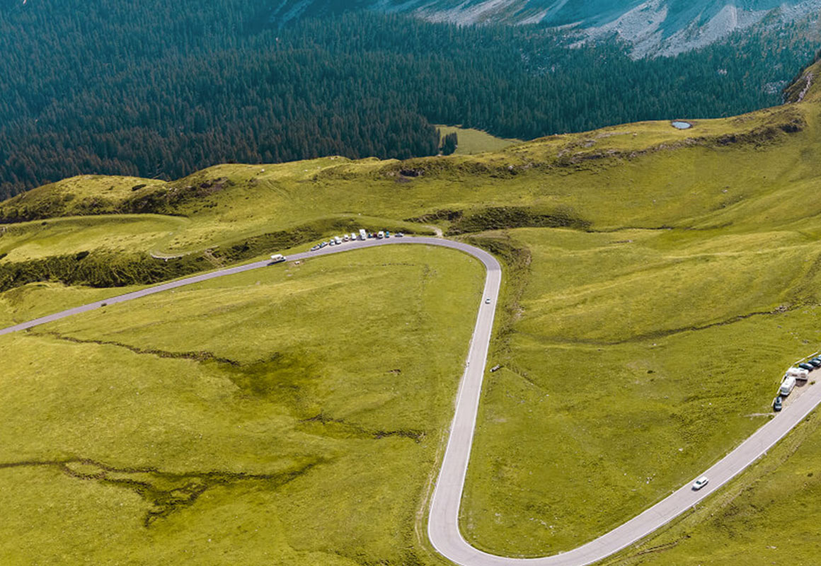Serpentinen eingebettet in grüne Wiesen